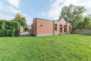 A brick building with a small front yard and a paved path leading to the entrance.