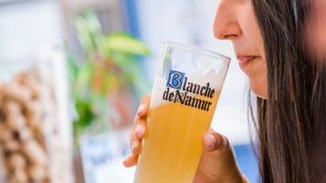 A person holding a glass with the text "Blanche de Namur" on it.