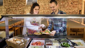 Un bufé con diversos alimentos y un muro de ladrillo al fondo.
