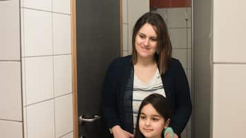 A bathroom with a mirror, a sink, and toiletries on the counter.