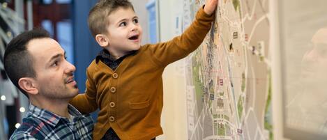 Un hombre y un niño observando un mapa grande en la pared.