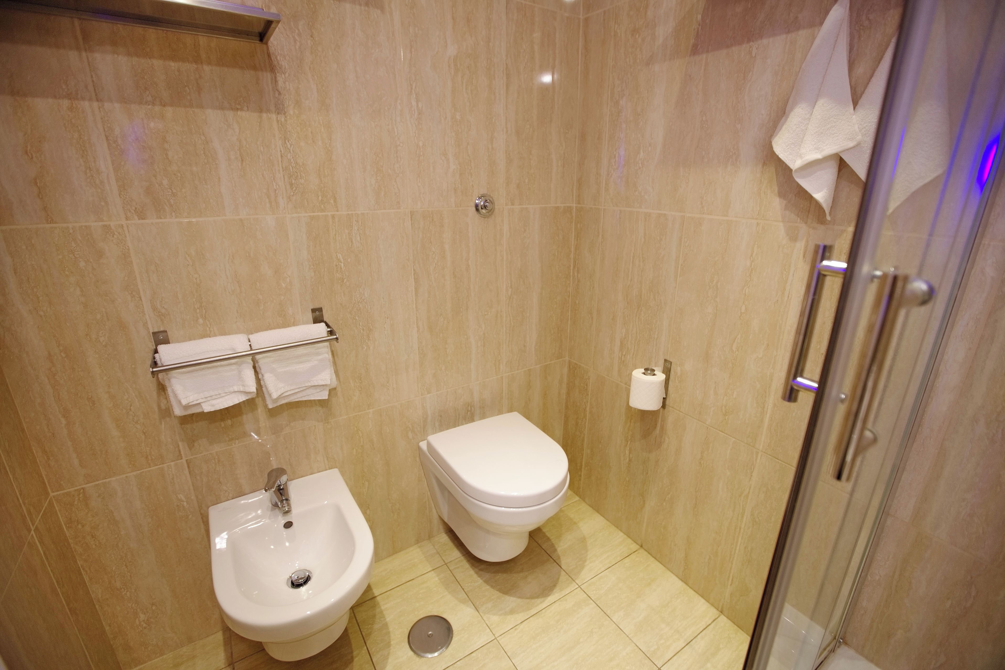A bathroom with a toilet, bidet, and sink.