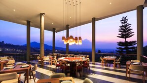 A restaurant with tables set for dining, large windows, and a view of the mountains. - Sirinati Khao Kho National Park (Khao Kho)