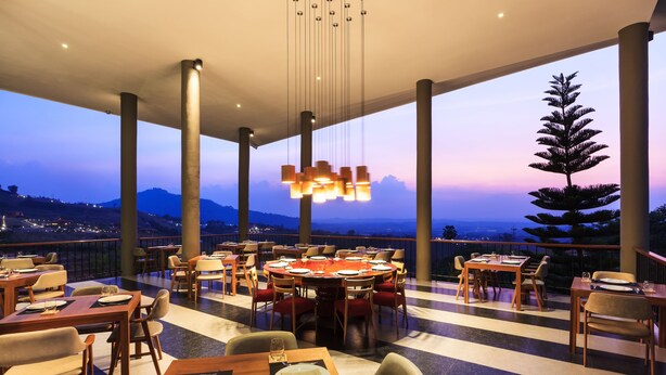 A restaurant with tables set for dining, large windows, and a view of the mountains. - Sirinati Khao Kho National Park (Khao Kho)