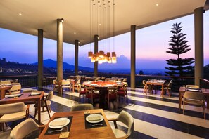 A restaurant with tables set for dining, large windows, and a view of the mountains. - Sirinati Khao Kho National Park (Khao Kho)