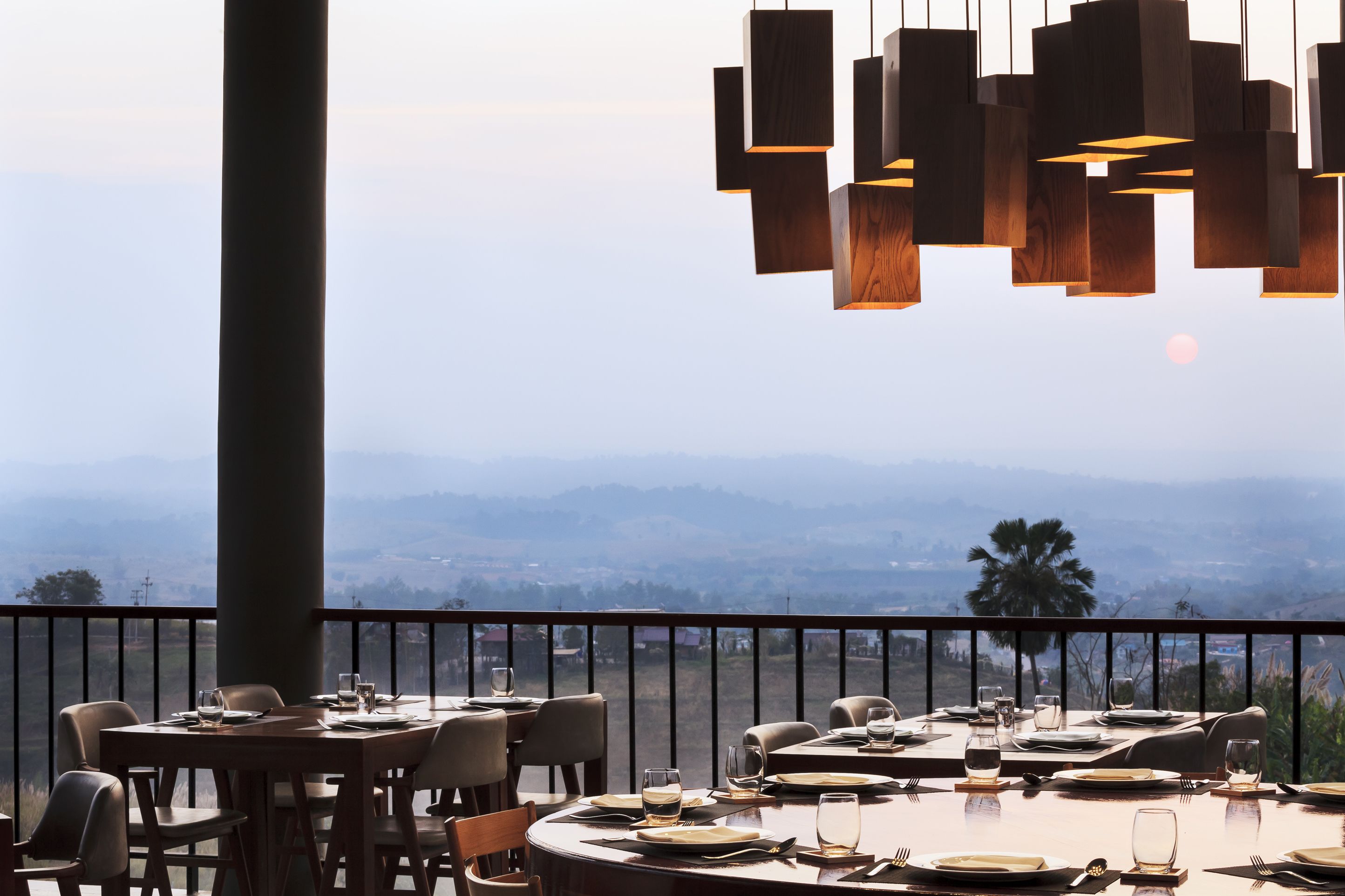 Un restaurante con mesas dispuestas para comer, con vistas a un paisaje montañoso.