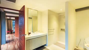 A modern bathroom with a large mirror, a sink, and a shower area.