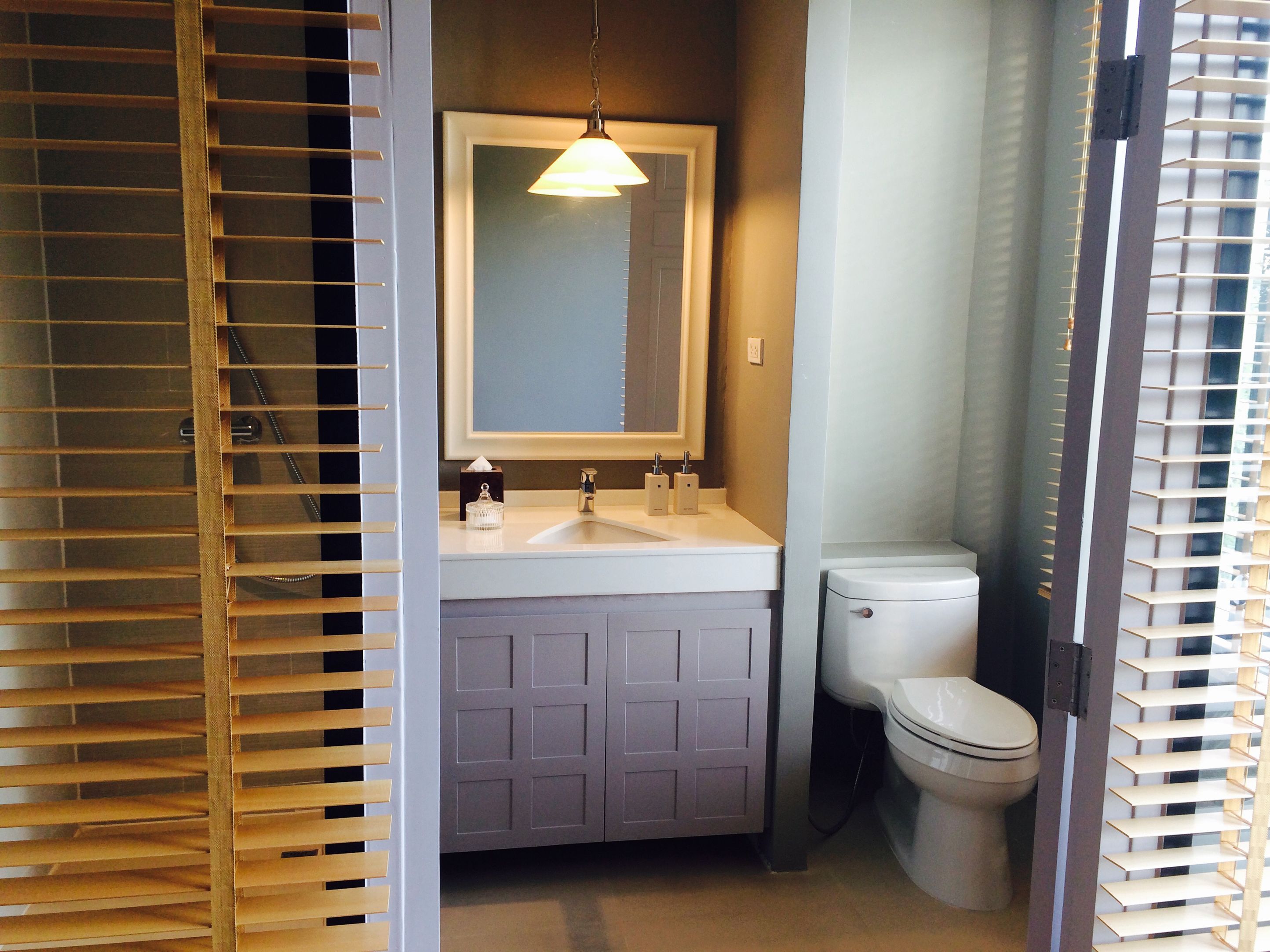 A bathroom with a white sink, a mirror, and a toilet.