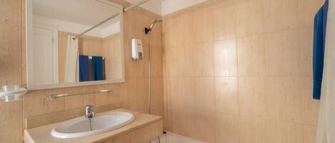 Une salle de bain avec un lavabo, un miroir et une baignoire.