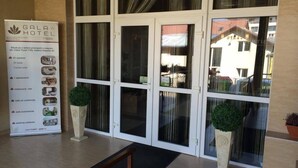 A hotel entrance with a signboard detailing amenities like rooms, a restaurant, and parking. - Hotel Gala (Cluj-Napoca)