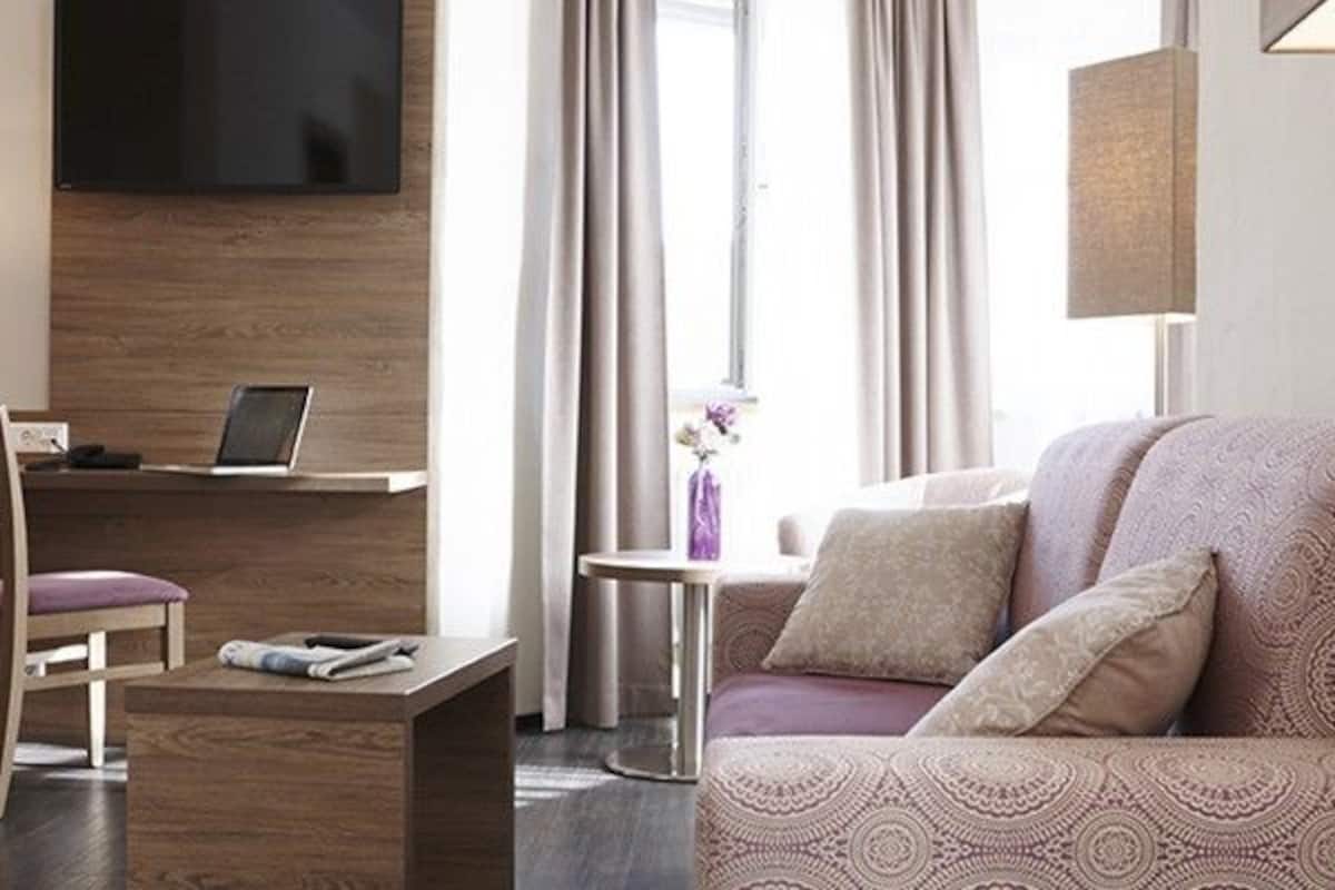 deluxe suite, 1 bedroom, city view | living area | flat-screen tv