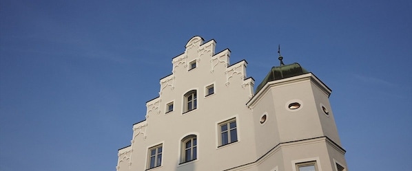 A building with a unique architectural style, featuring multiple levels and a prominent tower with a spire. - Boutique Hotel zur Post (Vohburg an der Donau)