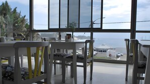 Ein moderner Essbereich mit weißen Möbeln und Blick aufs Meer.