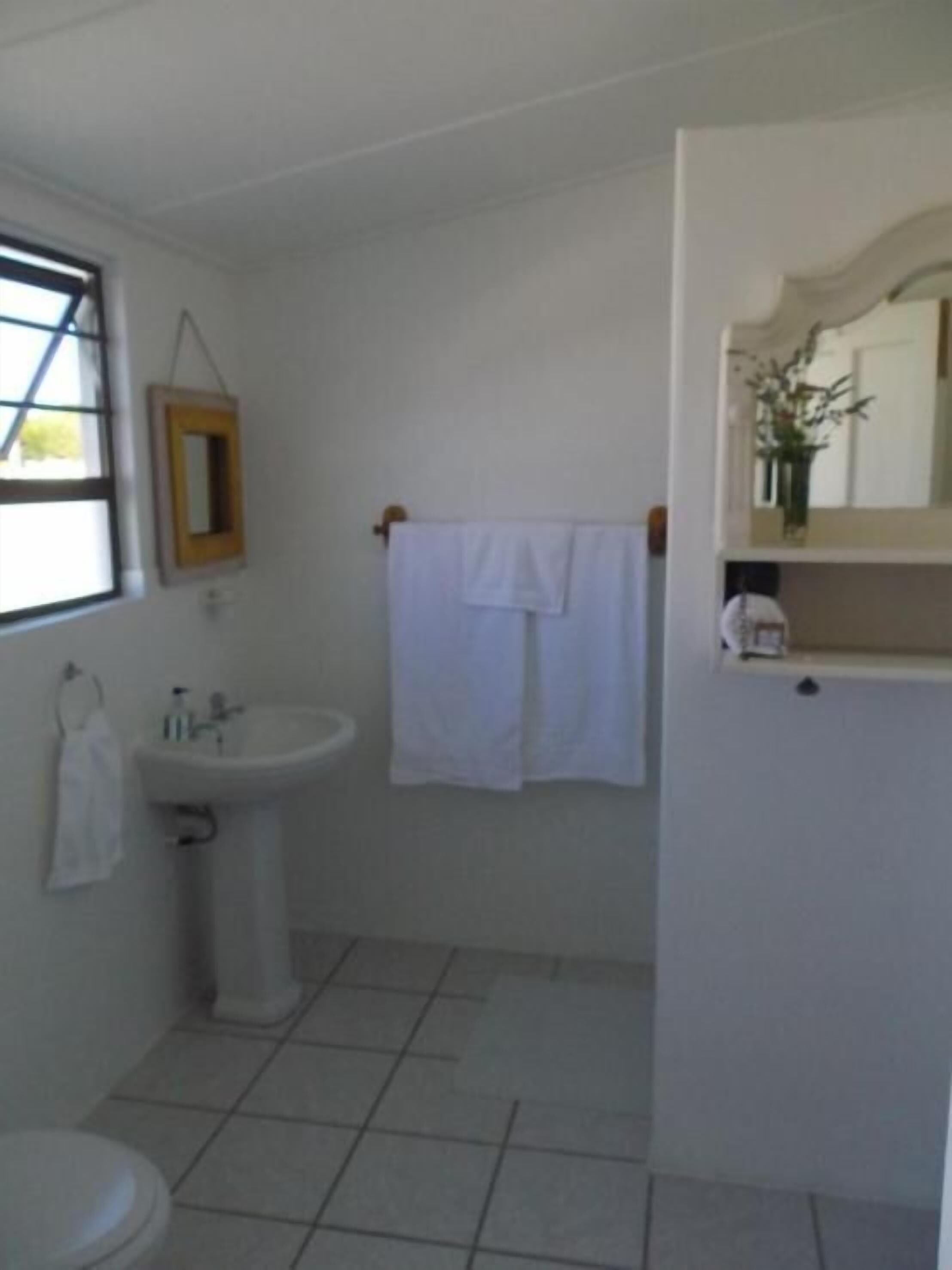 Un baño con inodoro, lavabo y espejo.