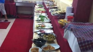 Una mesa de buffet con distintos alimentos y utensilios.
