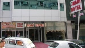 Un edificio de varios pisos con un letrero que dice 'MADI HOTEL' en la planta baja.