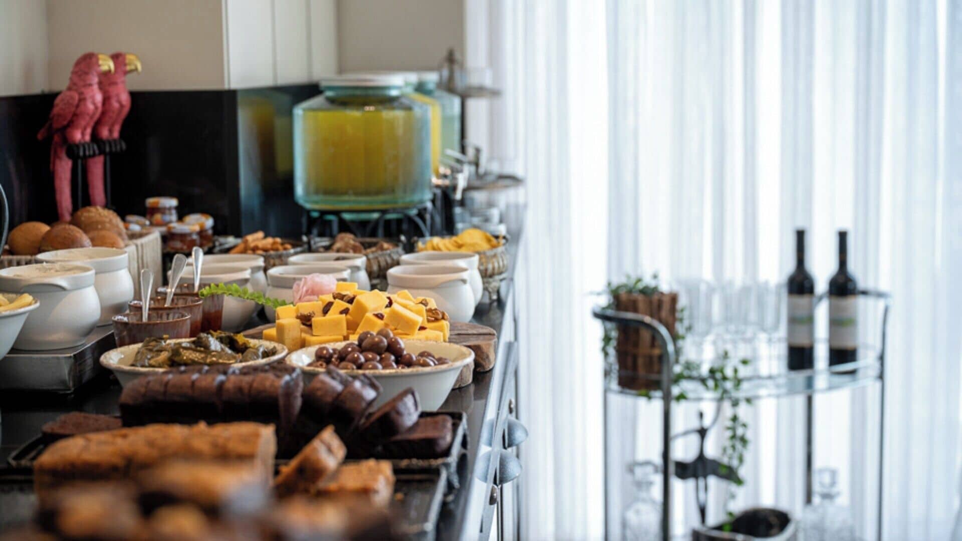 A buffet setup with various food items and a wine selection.