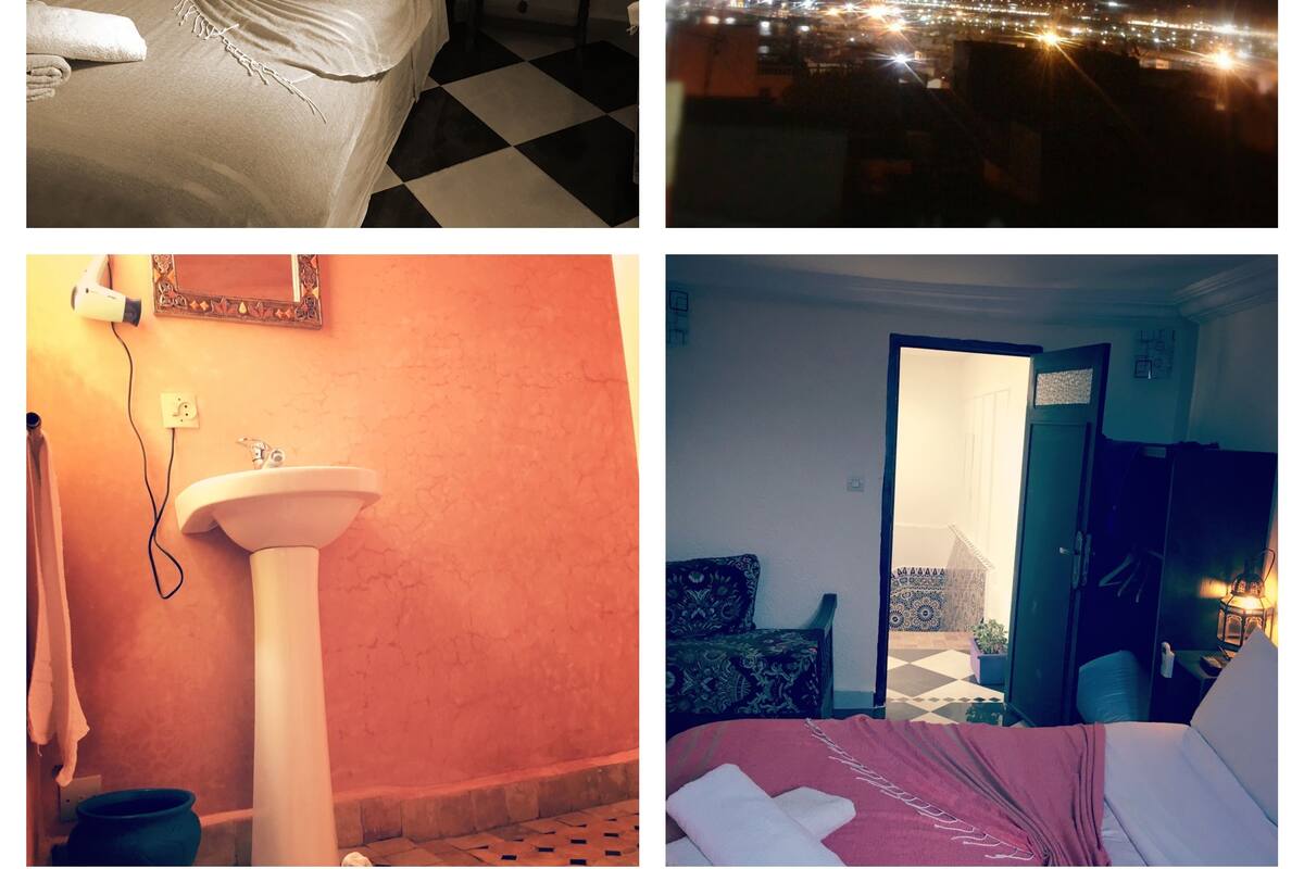 A bed with a checkered floor, a night view of a cityscape, a bathroom with a sink, and a room with a bed and a door.