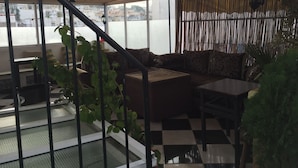 Un rincón interior acogedor con suelo a cuadros, un sofá y una mesita.