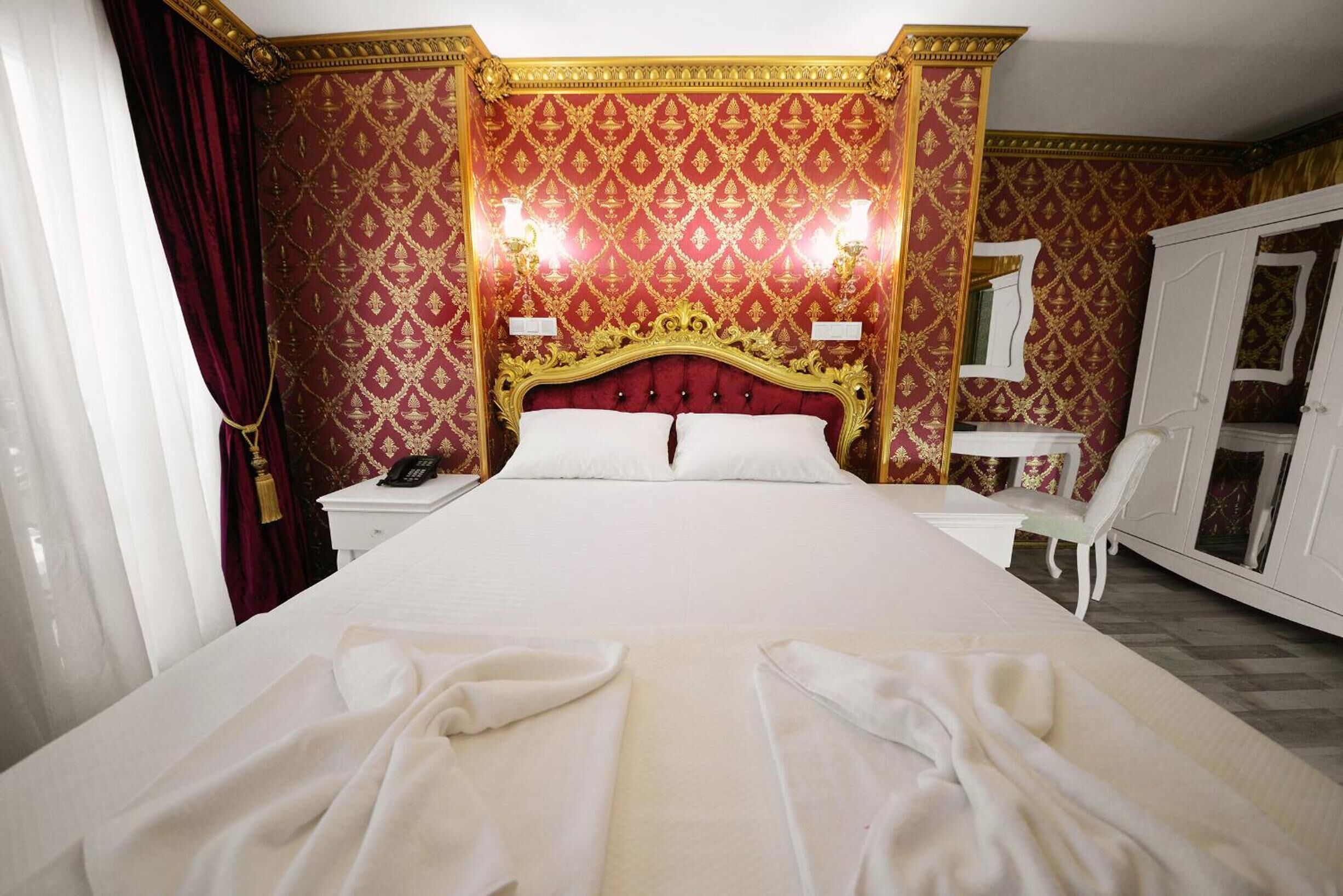 Une chambre d’hôtel avec un grand lit, un bureau et une armoire.