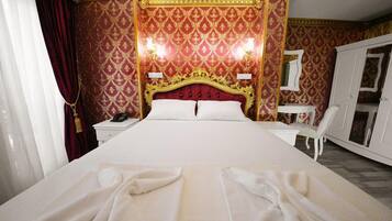 Une chambre d’hôtel avec un grand lit, un bureau et une armoire.
