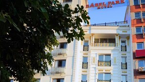An outdoor café area with tables and chairs, a building with a sign reading "Babel Park Hotel", and another sign for "Bagdat Sarasi". - Babel Park Hotel (Istanbul)
