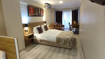 Una habitación de hotel con una cama, mesita de noche, lámpara y un cuadro en la pared.