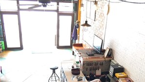 A kitchen area with a counter, stools, and various kitchen appliances.