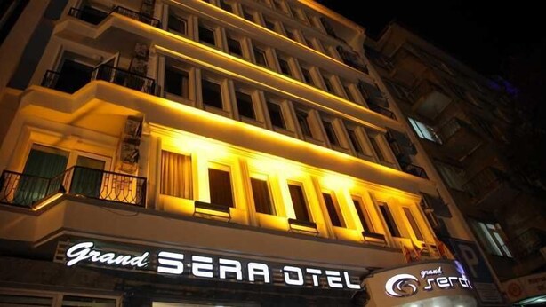 Un hotel llamado "Grand SEARA OTEL" con un diseño arquitectónico clásico, que presenta varios balcones y ventanas iluminadas.