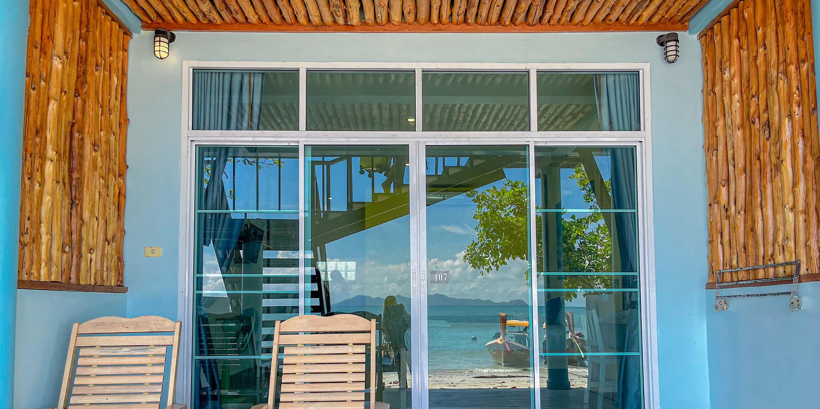 A modern building with a glass door leading to a beach view.