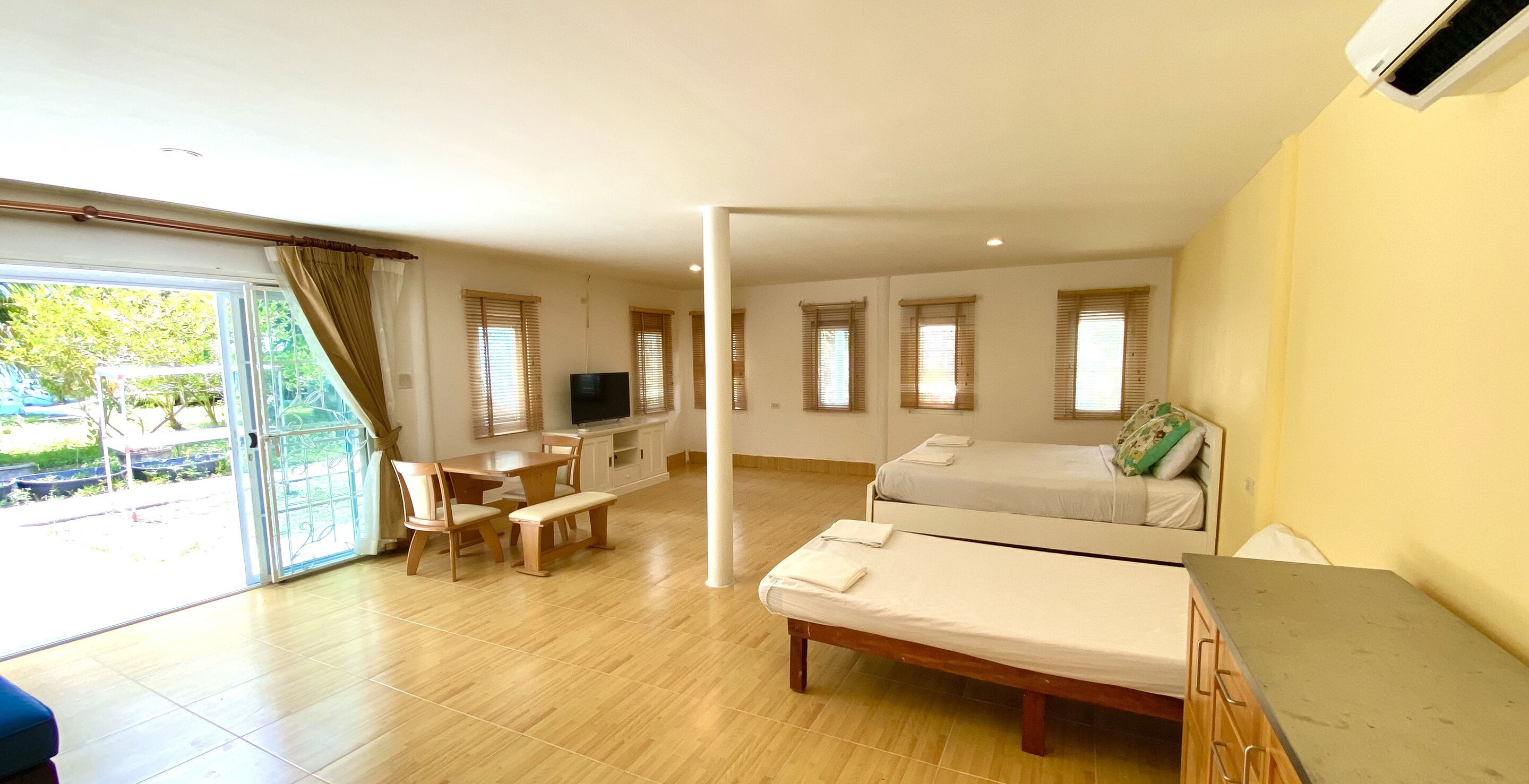 Una habitación con cama, escritorio, silla y televisión.