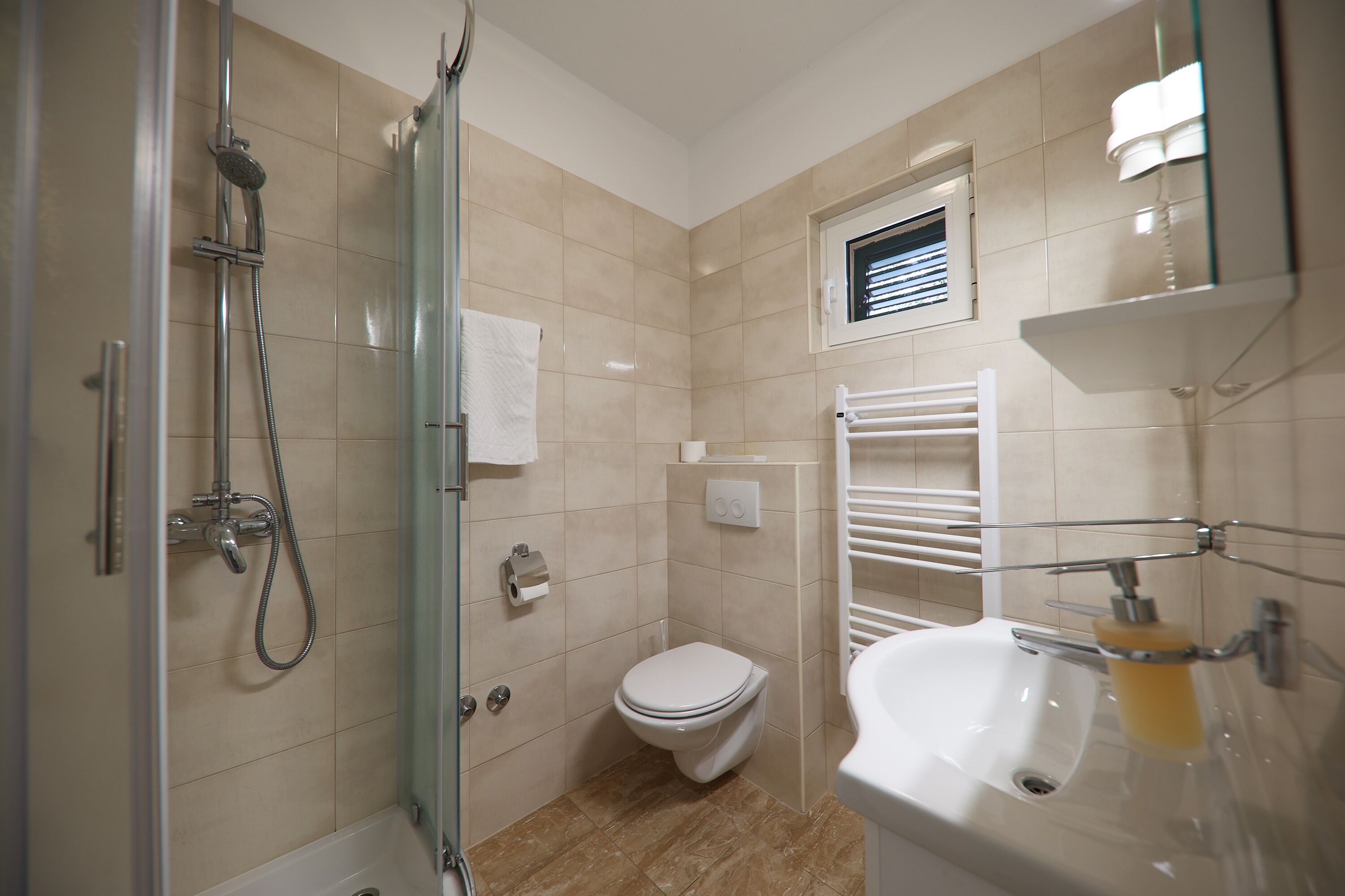 A bathroom with a shower, toilet, and sink.