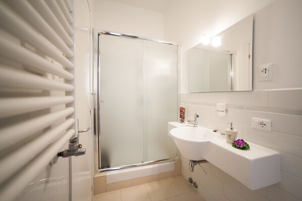 A modern bathroom with a glass shower enclosure, a white sink, and a mirror above it. - B&B Vatican's Keys (Rome)