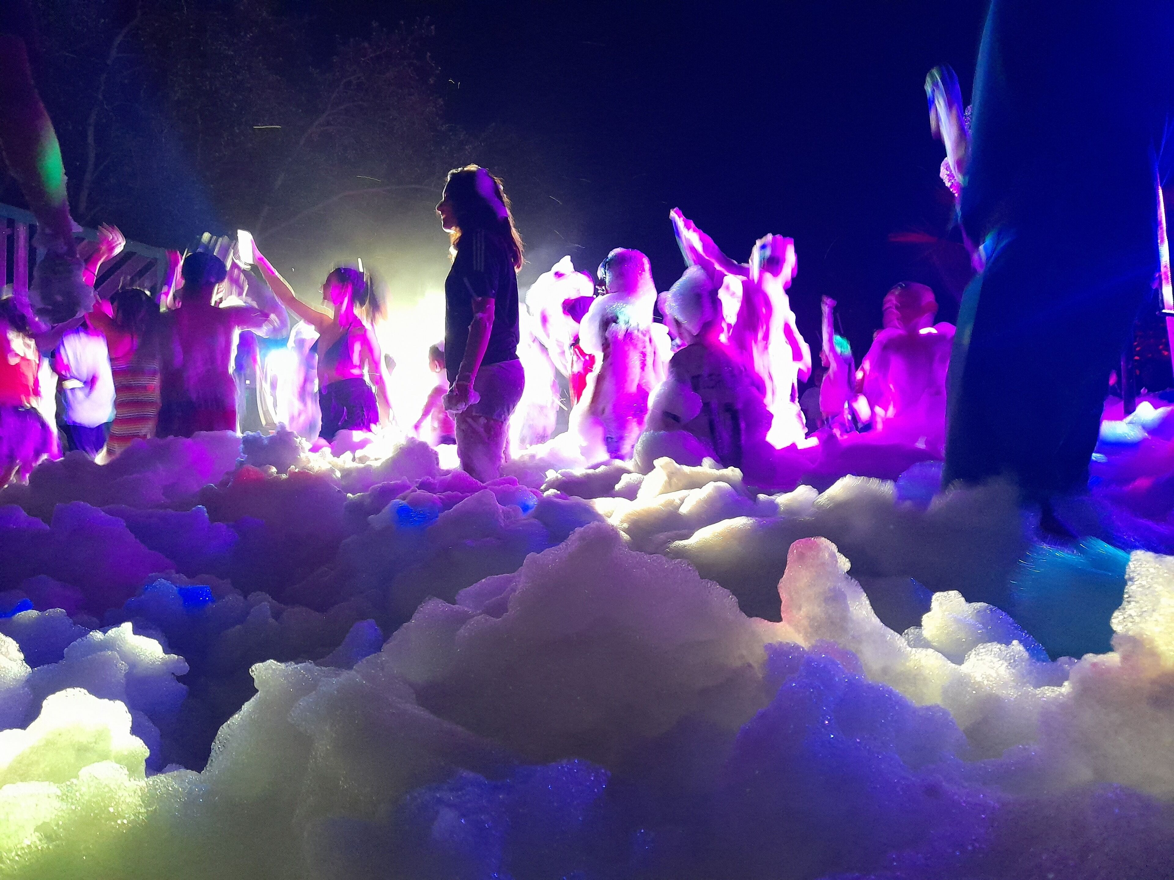 A group of people in a snowy environment with colorful lights.