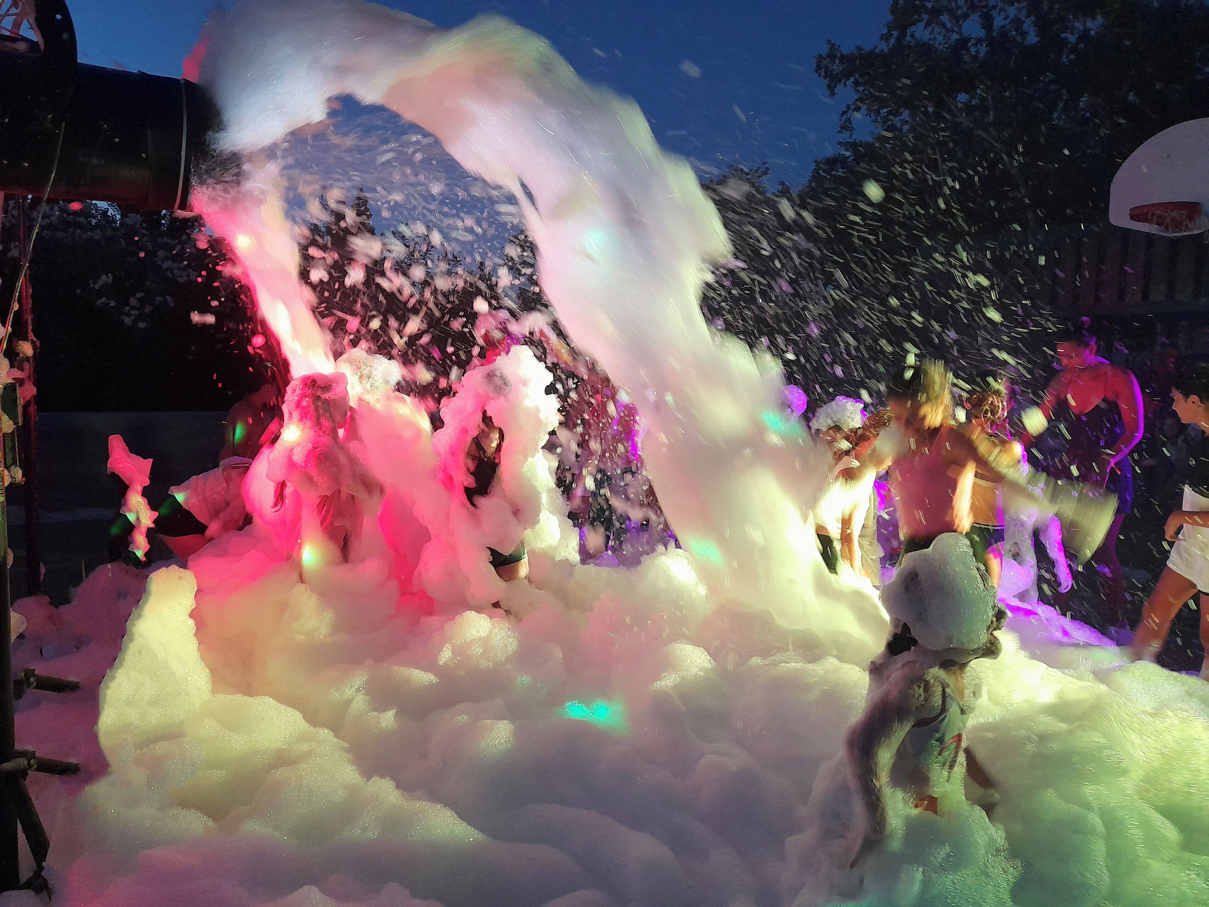 A large, colorful foam structure with people interacting around it.