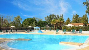 A swimming pool with lounge chairs and a water feature. - Azureva Le Grau du Roi (Le Grau-Du-Roi)