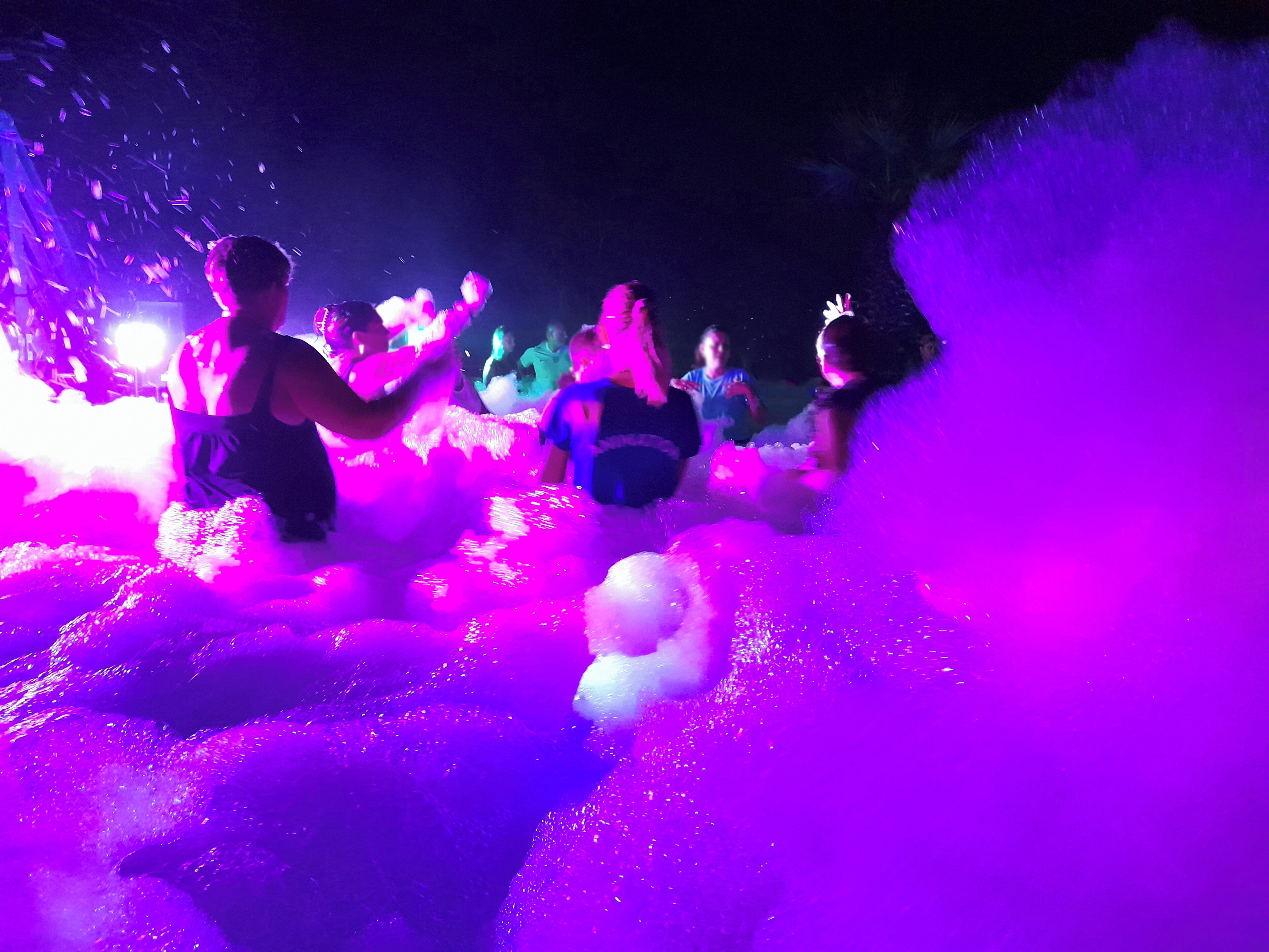 A group of people in a room with a large, colorful foam installation.