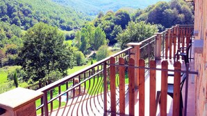 A balcony with a wooden railing overlooking a lush valley with dense greenery and distant hills. - Agriturismo La Rocca dei Briganti (Rocca Massima)