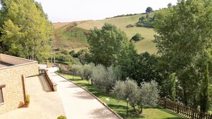 A pathway leading to a stone building with a stone wall and a wooden fence. - Agriturismo La Rocca dei Briganti (Rocca Massima)
