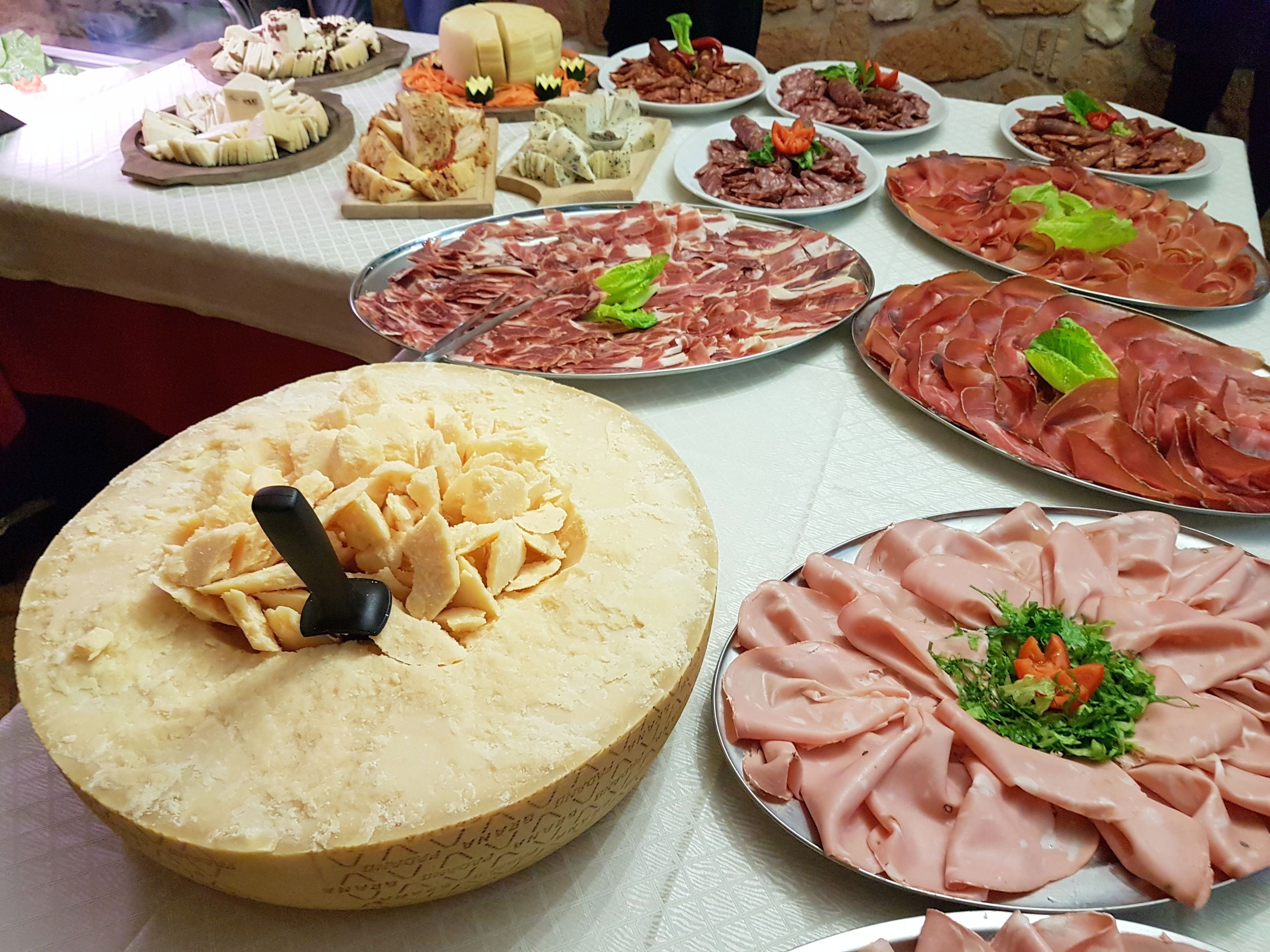 Une table de buffet proposant divers plats, notamment des fromages, des viandes et des salades.