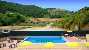 A pool area with a view of a mountainous landscape, outdoor seating, and umbrellas. - Agriturismo La Rocca dei Briganti (Rocca Massima)