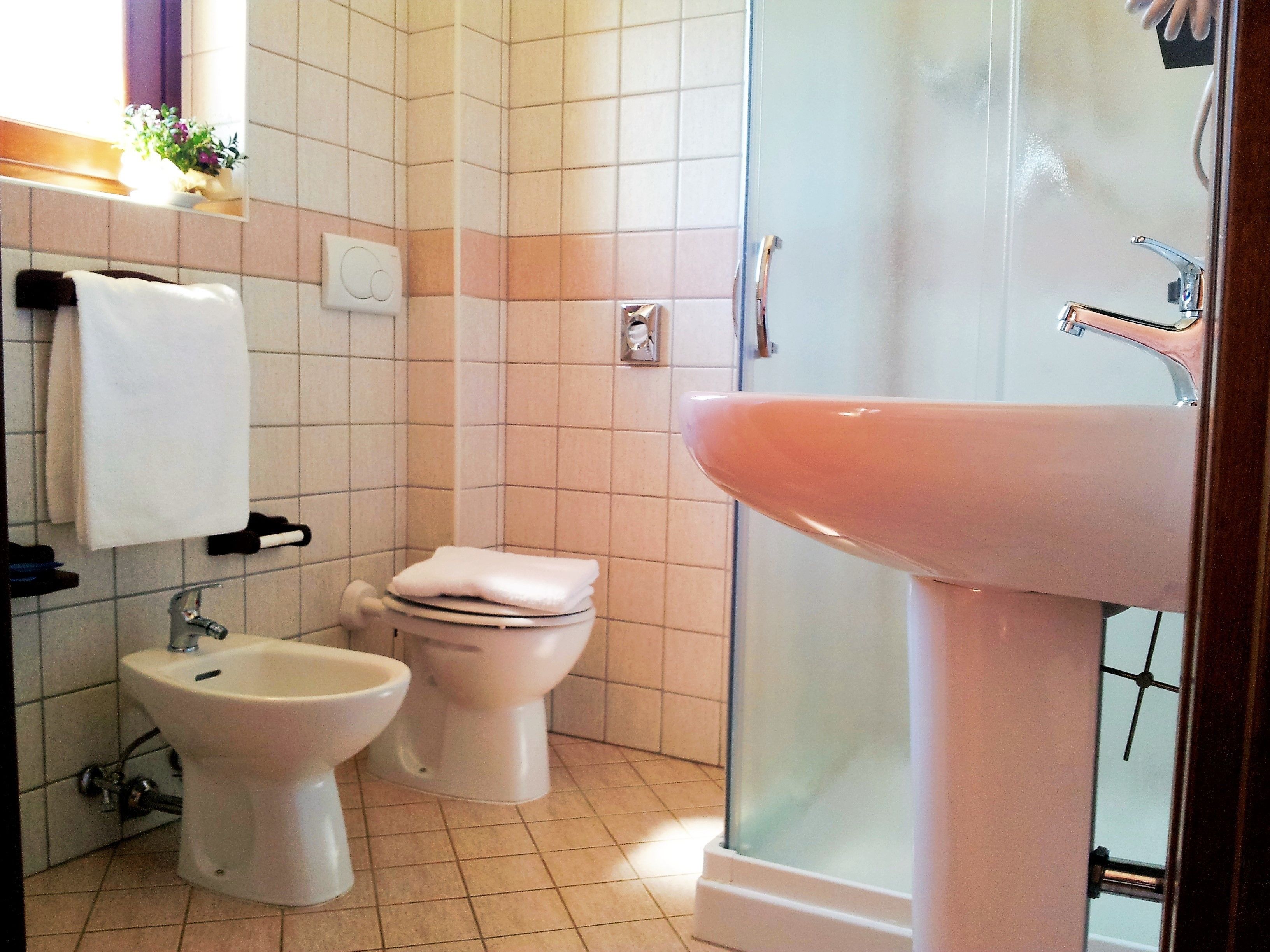 Un bagno con il water, un bidet e un lavandino.