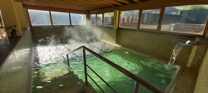 Un jacuzzi con interior de azulejos y techo de madera.