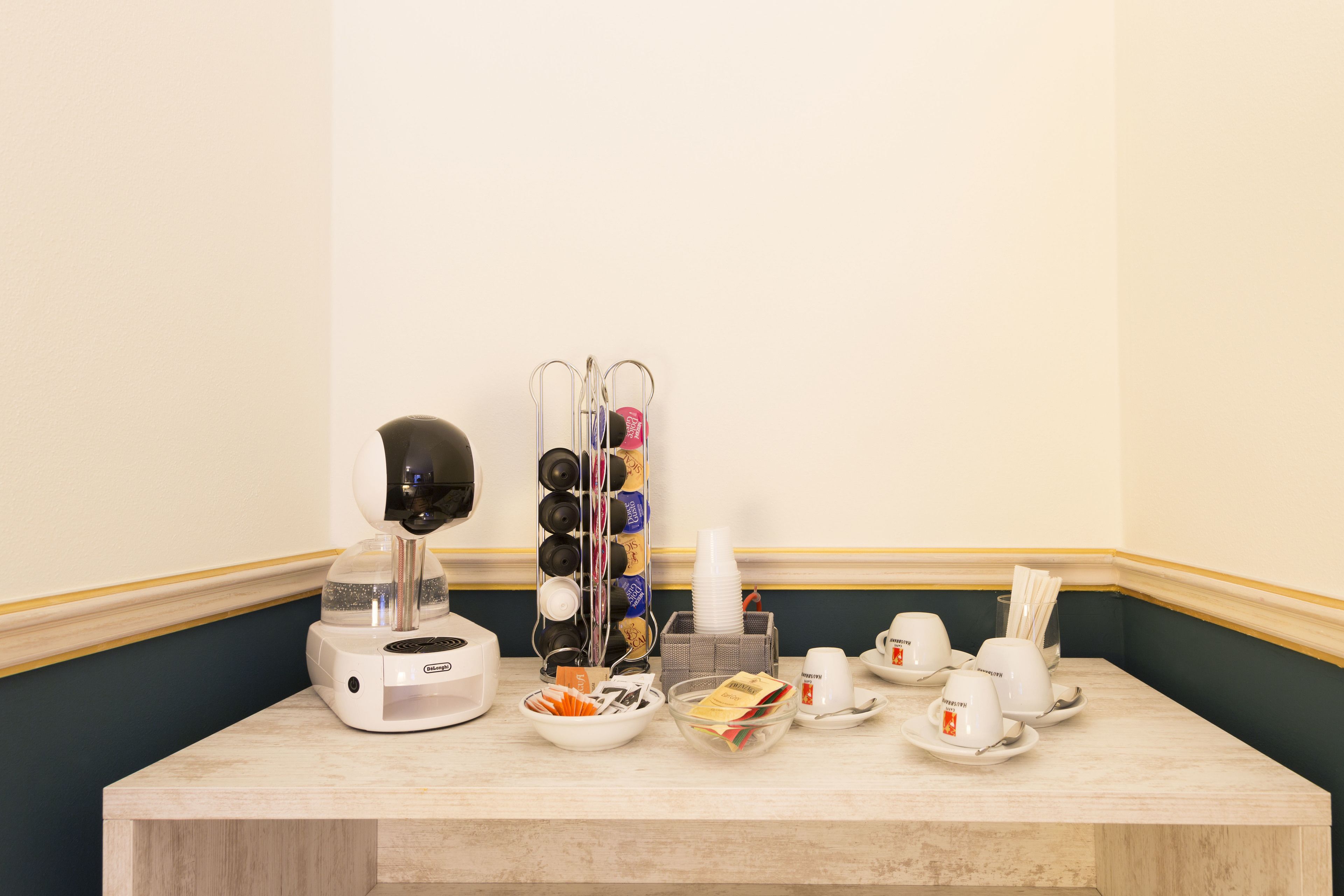 Une table de petit-déjeuner avec une machine à café, des tasses, des bols et un bol de céréales, le tout posé sur un comptoir en marbre.