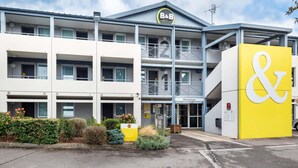 A B&B hotel with a yellow & sign, multiple balconies, and a welcoming entrance. - B&B HOTEL Nantes Parc Expos La Chapelle (La Chapelle-sur-Erdre)