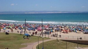 A beach with umbrellas and people. - The Mandyville (Jeffreys Bay)