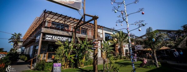 Un edificio con un letrero que dice "FACTORY SHOP" y una señal con indicaciones.
