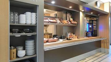 A breakfast bar with various food items and utensils.