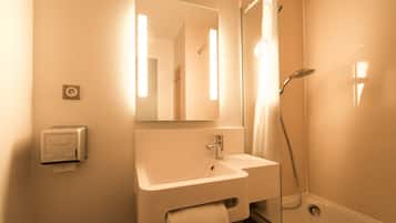 Une salle de bain avec un lavabo, un miroir et une douche.