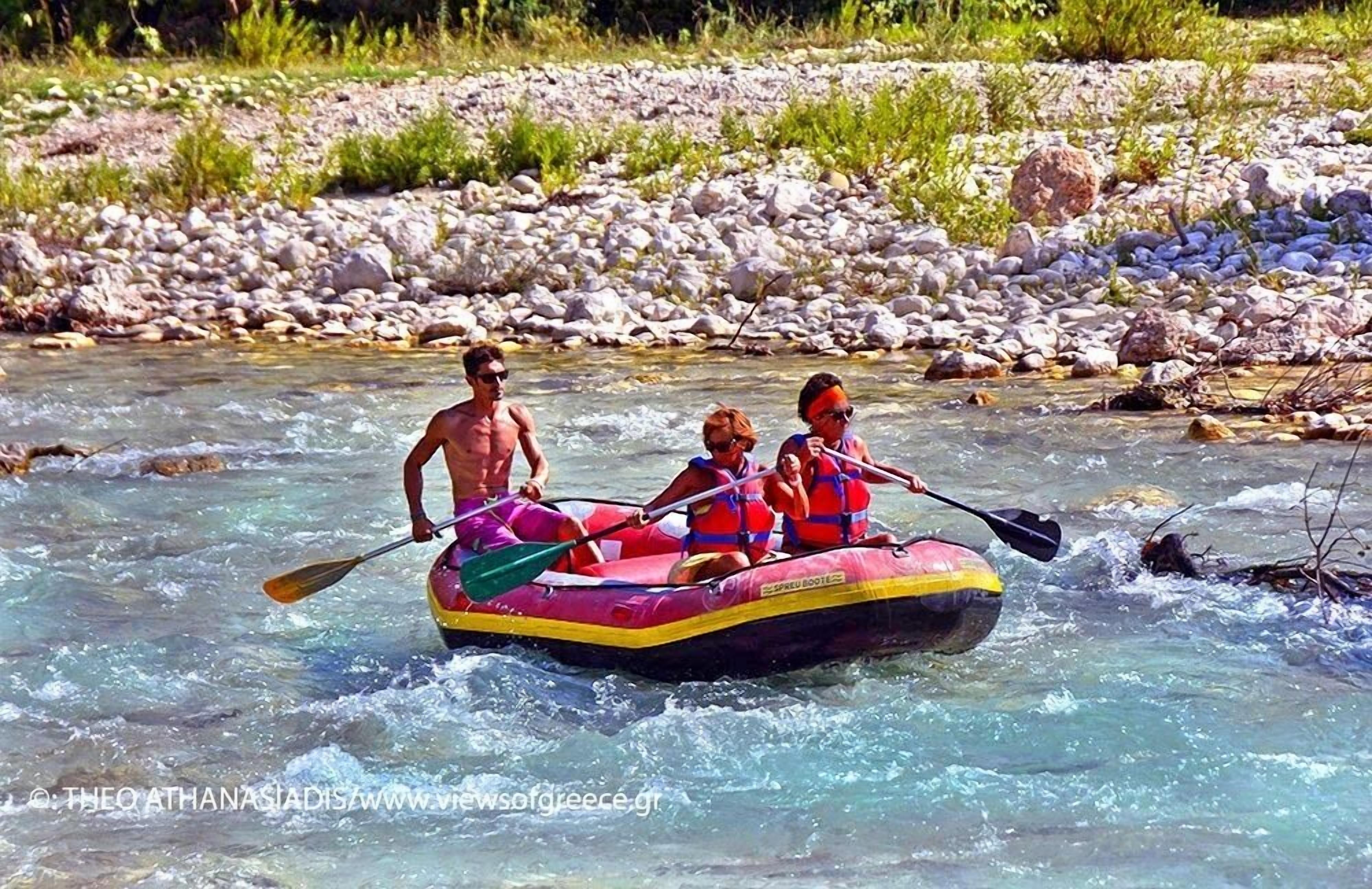 Un gruppo di persone fa rafting su un fiume circondato da rocce e vegetazione.